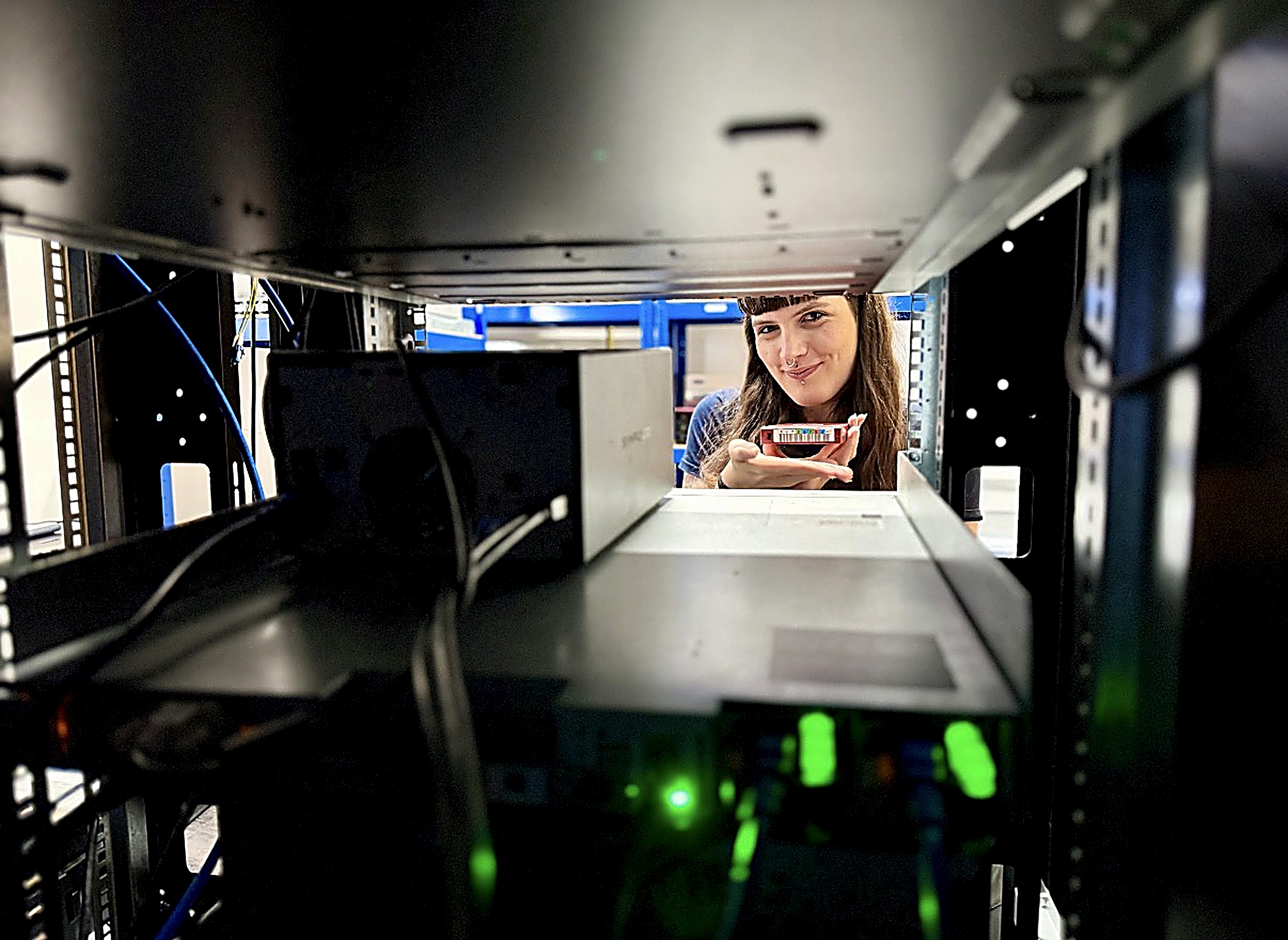 runVT engineer holding a drive inside the master control room equipment racks